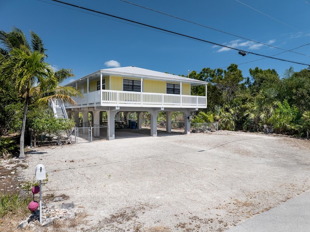 view of front of home featuring a carport, covered porch, and driveway