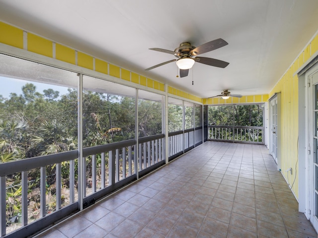 unfurnished sunroom with ceiling fan