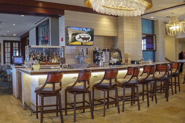 bar featuring an inviting chandelier and wood walls