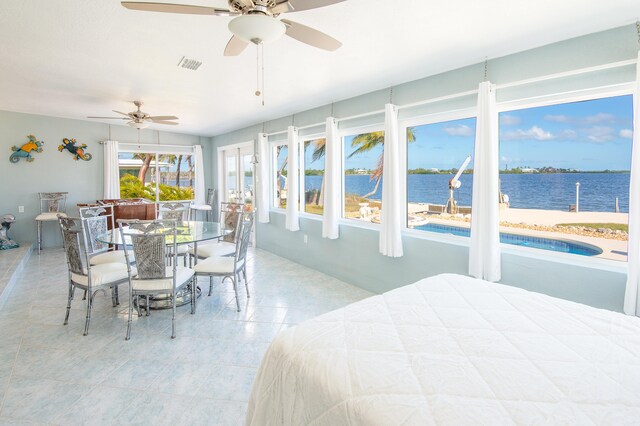 bedroom with a water view and light tile patterned floors