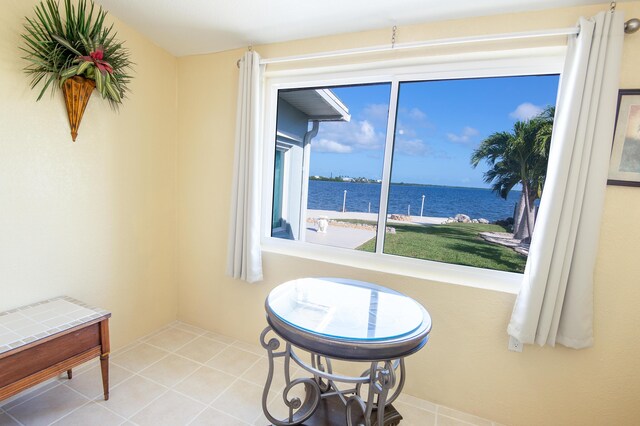 sitting room with a water view and light tile patterned flooring