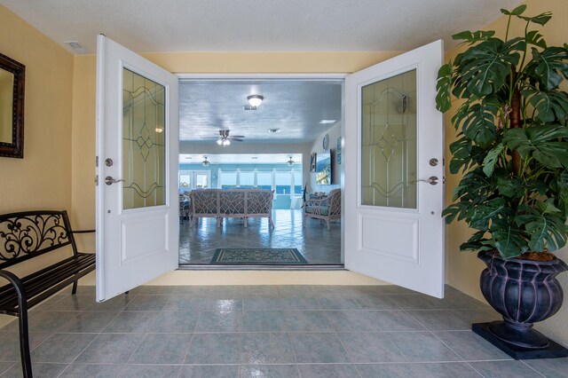 tiled foyer entrance featuring ceiling fan