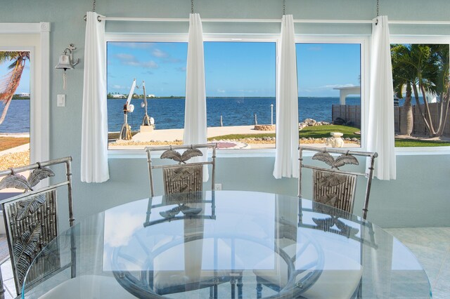 dining room featuring a water view and plenty of natural light