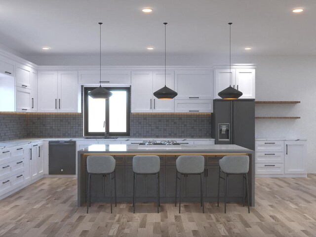 kitchen with decorative light fixtures, white cabinetry, sink, a center island, and black appliances