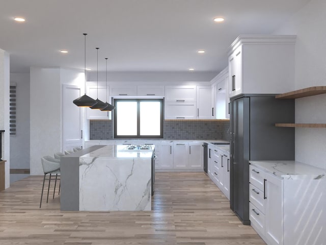 kitchen featuring a center island, light stone countertops, white cabinets, decorative light fixtures, and light wood-type flooring