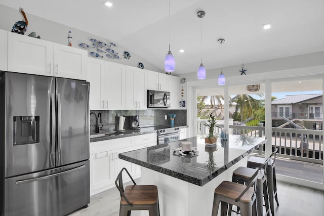 kitchen featuring white cabinetry, a breakfast bar area, stainless steel appliances, and a kitchen island