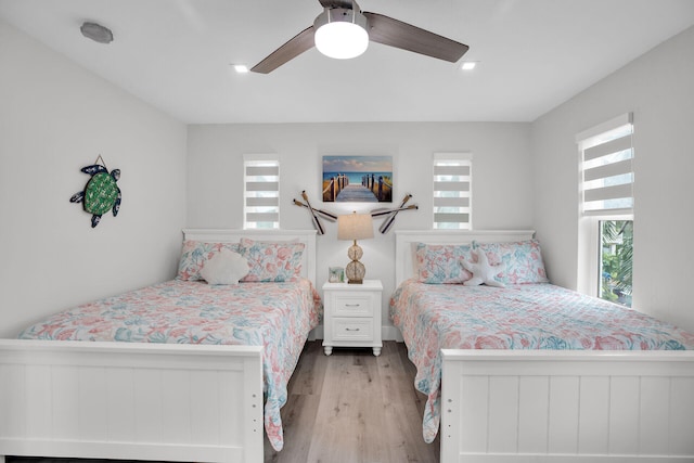 bedroom featuring multiple windows, ceiling fan, and light wood-type flooring