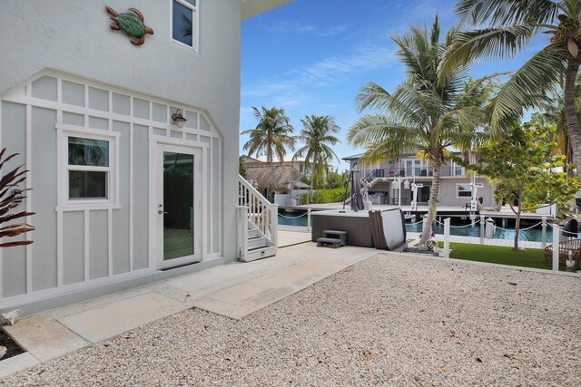 view of patio with a jacuzzi and a water view