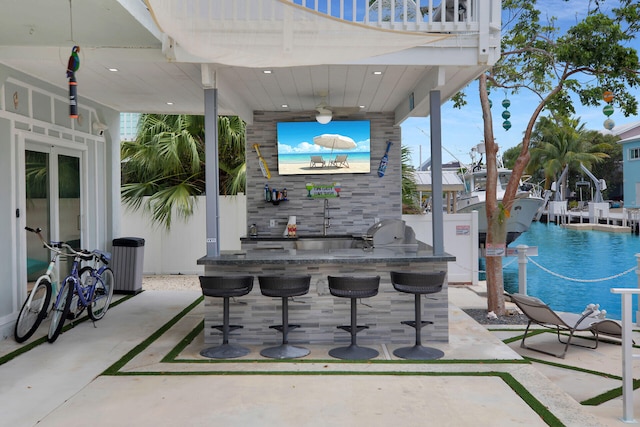 view of patio / terrace with exterior kitchen and an outdoor bar