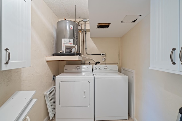 laundry room featuring cabinets, washing machine and dryer, and water heater