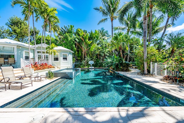 view of swimming pool featuring a patio, an outdoor structure, and an in ground hot tub