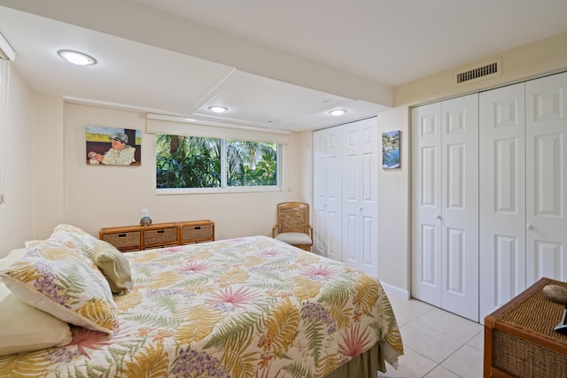 tiled bedroom featuring multiple closets