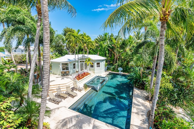 view of swimming pool with an in ground hot tub, an outdoor structure, and a patio