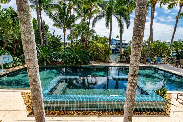 view of pool with an in ground hot tub