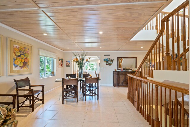 tiled dining space featuring crown molding and wooden ceiling