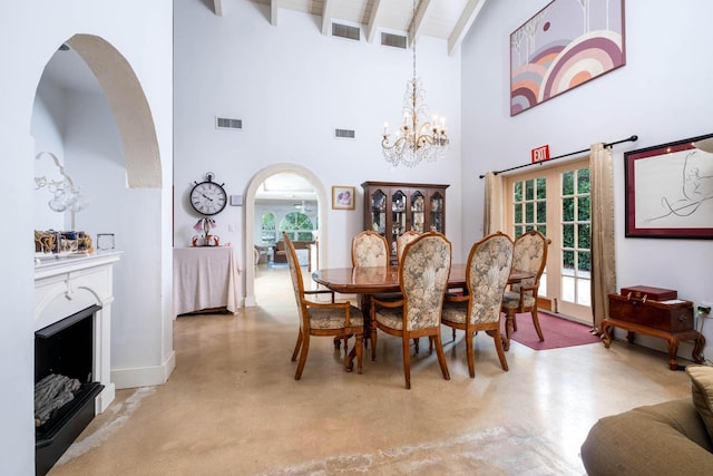 dining space featuring beam ceiling, arched walkways, healthy amount of natural light, a chandelier, and a towering ceiling