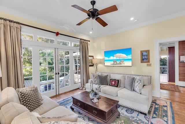 living room with crown molding, french doors, ceiling fan, and light wood-type flooring