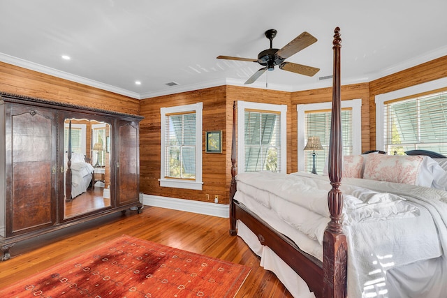 unfurnished bedroom with crown molding, hardwood / wood-style floors, and wood walls