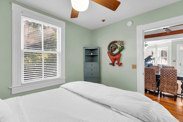 bedroom featuring multiple windows, hardwood / wood-style floors, and ceiling fan