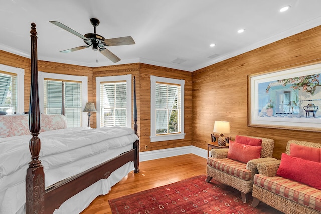 bedroom with crown molding, hardwood / wood-style flooring, and ceiling fan