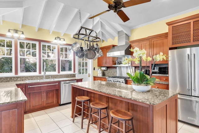 kitchen featuring extractor fan, a kitchen island, light stone countertops, and appliances with stainless steel finishes