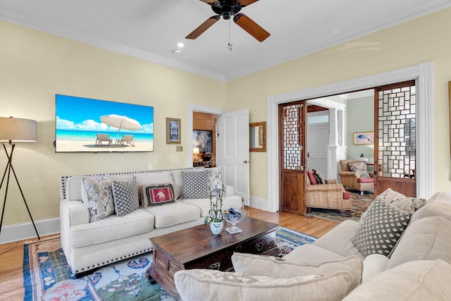 living room featuring wood-type flooring, ornamental molding, and ceiling fan