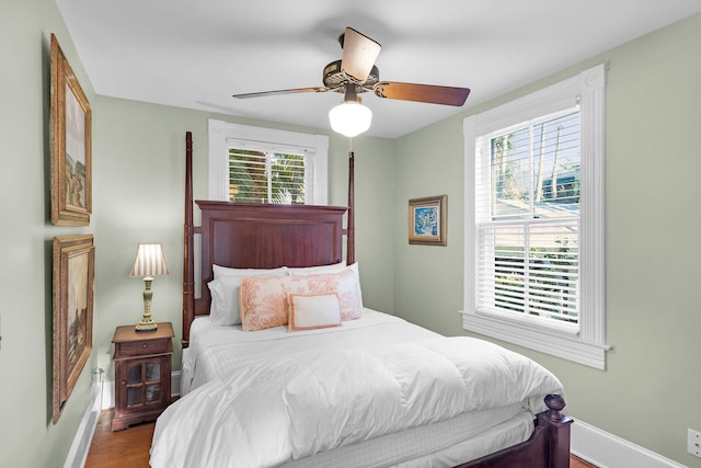 bedroom with multiple windows, hardwood / wood-style floors, and ceiling fan