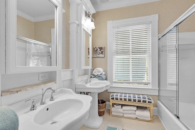 bathroom with enclosed tub / shower combo, crown molding, and sink