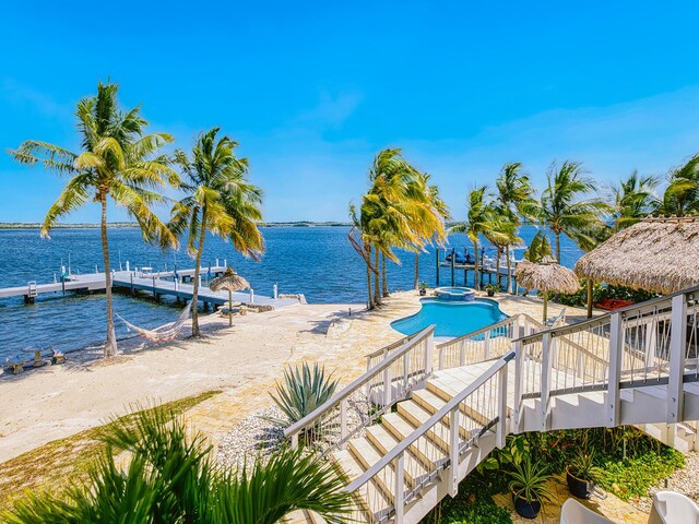 view of pool with a patio area, a dock, and a water view