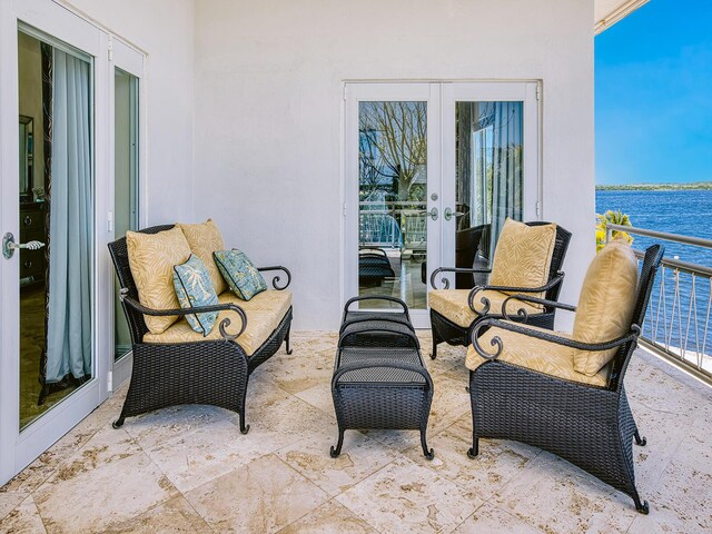 view of patio featuring french doors, a balcony, and a water view