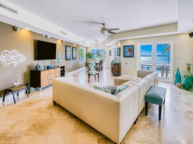 living room with ceiling fan and a tray ceiling