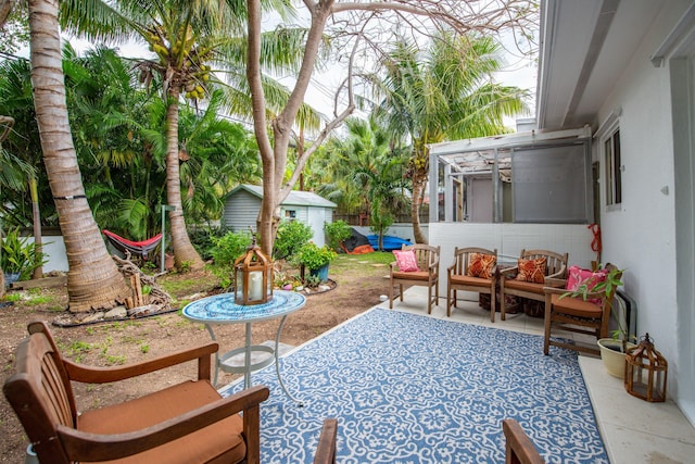 view of patio featuring a storage unit and an outdoor structure