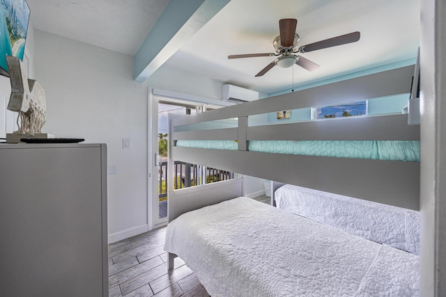 bedroom with a wall mounted air conditioner, hardwood / wood-style floors, ceiling fan, and access to exterior