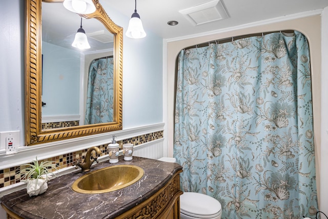 bathroom with ornamental molding, vanity, toilet, and backsplash