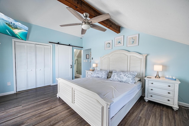 bedroom with dark hardwood / wood-style flooring, lofted ceiling with beams, a barn door, and ceiling fan