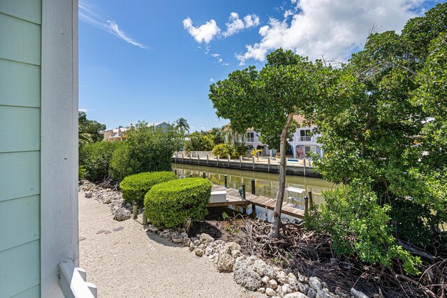 view of yard featuring a boat dock and a water view