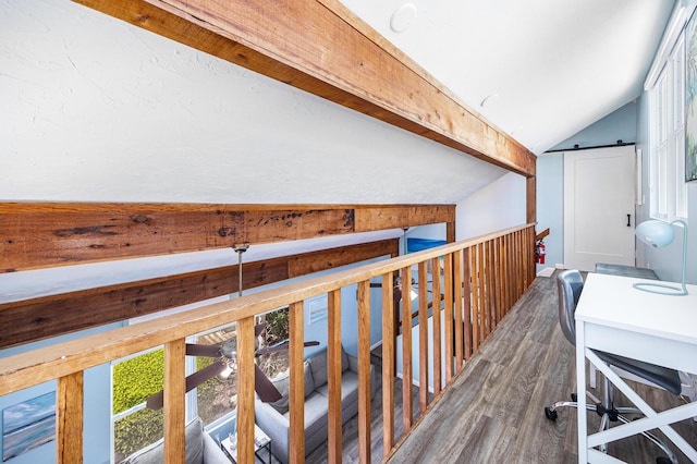 hall featuring lofted ceiling with beams, a barn door, and hardwood / wood-style floors