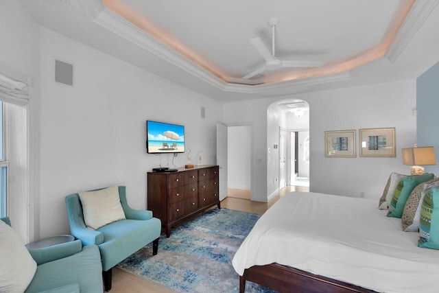 bedroom featuring crown molding, a tray ceiling, and light hardwood / wood-style floors