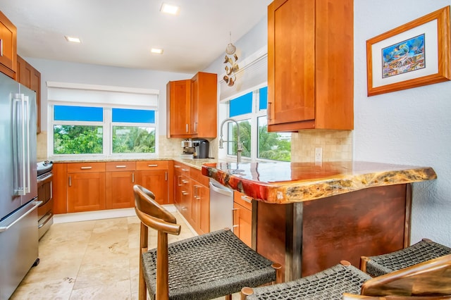 kitchen featuring tasteful backsplash, stainless steel appliances, sink, and light stone counters