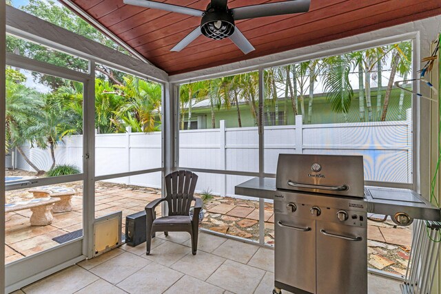 sunroom featuring vaulted ceiling, wooden ceiling, and ceiling fan