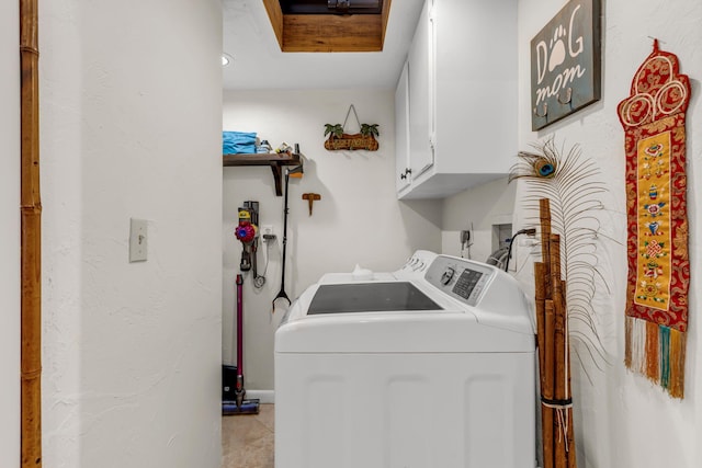 clothes washing area with cabinets and washer and dryer