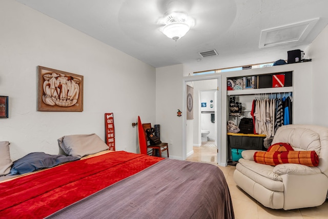 bedroom with light tile patterned floors and ensuite bathroom