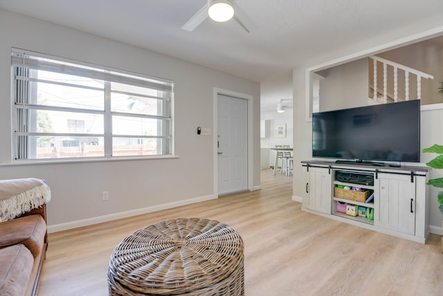 living room with light hardwood / wood-style floors and ceiling fan