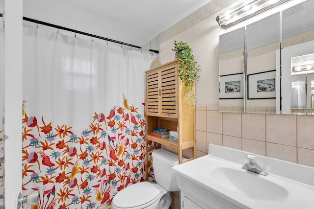 bathroom with vanity, toilet, tile walls, and backsplash