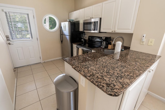 kitchen featuring appliances with stainless steel finishes, kitchen peninsula, and white cabinets