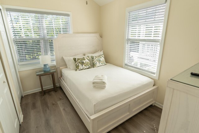 bedroom with dark hardwood / wood-style flooring