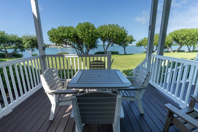 wooden terrace featuring a water view and a lawn