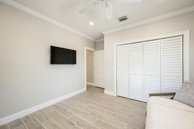 unfurnished bedroom with wood finish floors, visible vents, baseboards, a closet, and crown molding