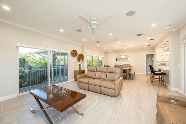 living room featuring ornamental molding, ceiling fan, and light wood-type flooring