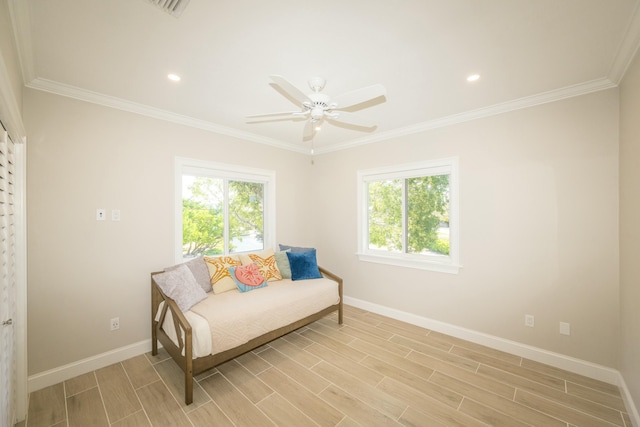 living area with ceiling fan, crown molding, and a healthy amount of sunlight